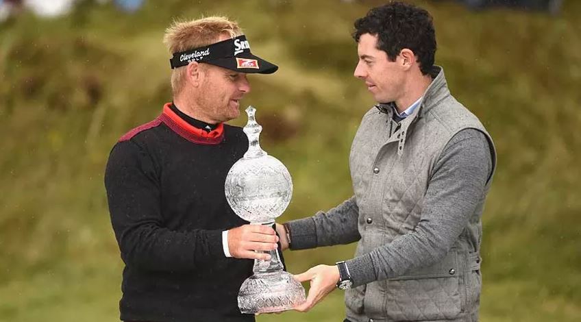 Soren Kjeldsen, receives the Irish Open trophy from tournament host Rory McIlroy, who missed the cut Friday. (Ross Kinnaird/Getty Images)